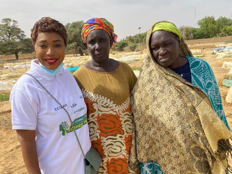 Tre donne stanno al sole in una fattoria nel nord-est del Senegal.