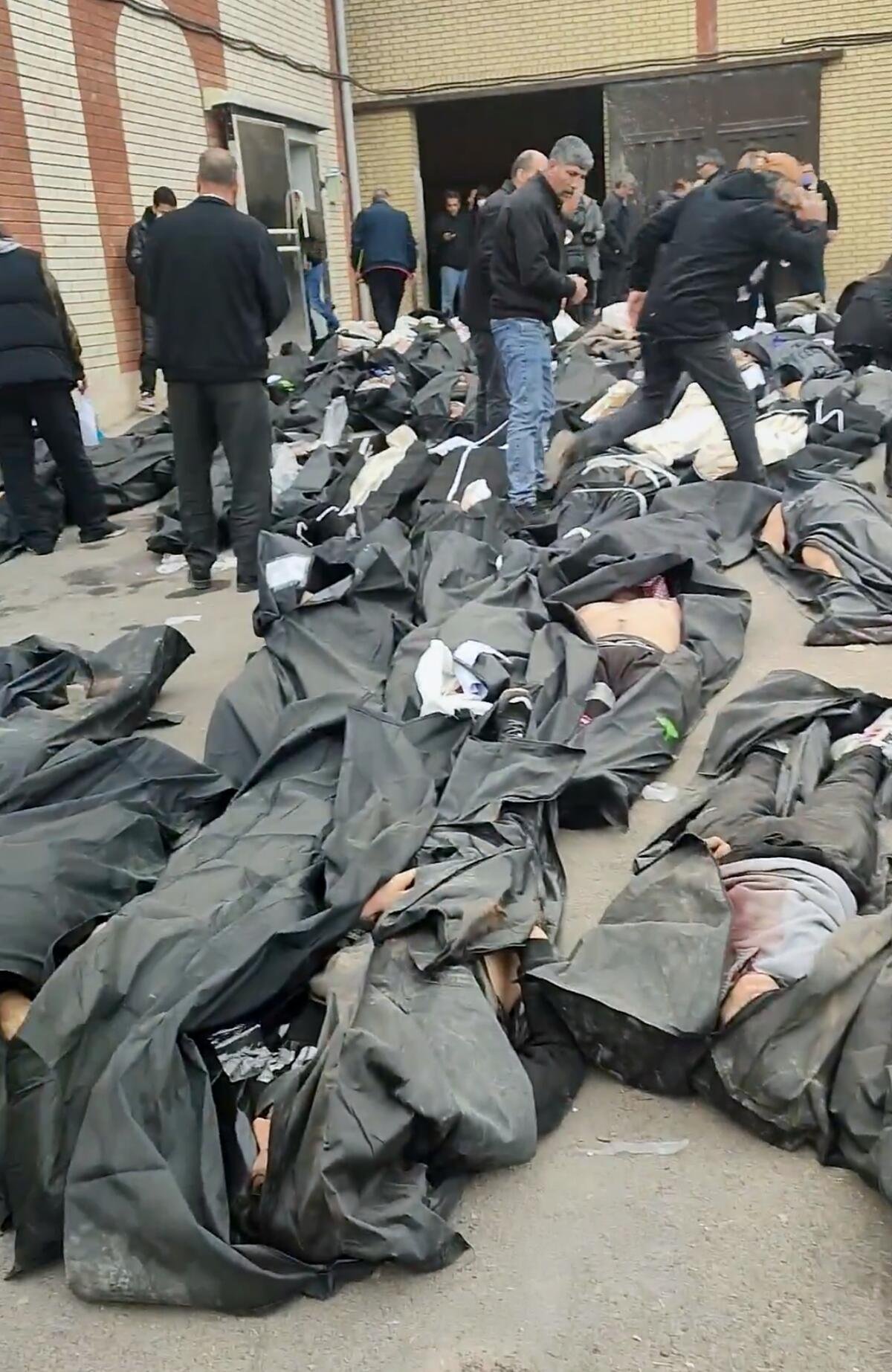 Questo fotogramma mostra le immagini di un obitorio con dozzine di corpi e persone in lutto