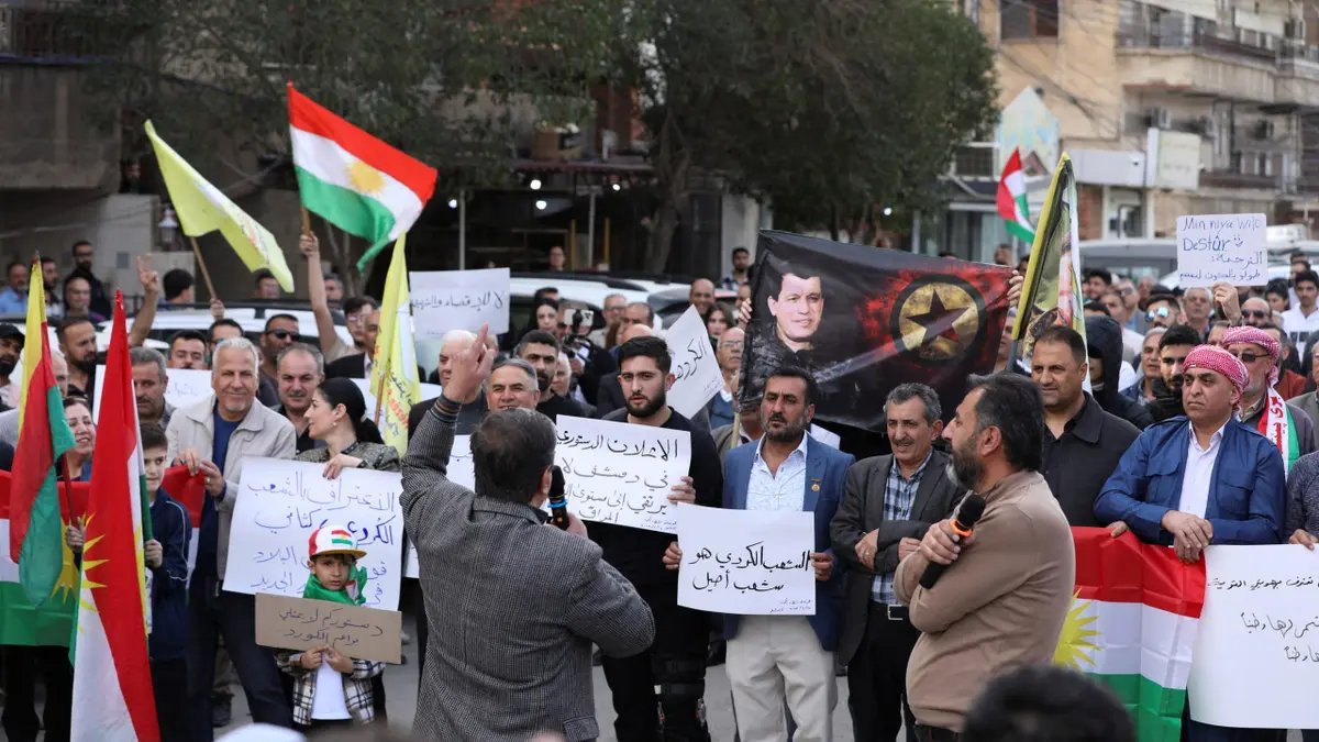 Persone che portano bandiere curde manifestano contro la dichiarazione costituzionale redatta da esperti e firmata dal presidente ad interim siriano Ahmed al-Sharaa giovedì a Qamishli, Siria, 14 marzo 2025.