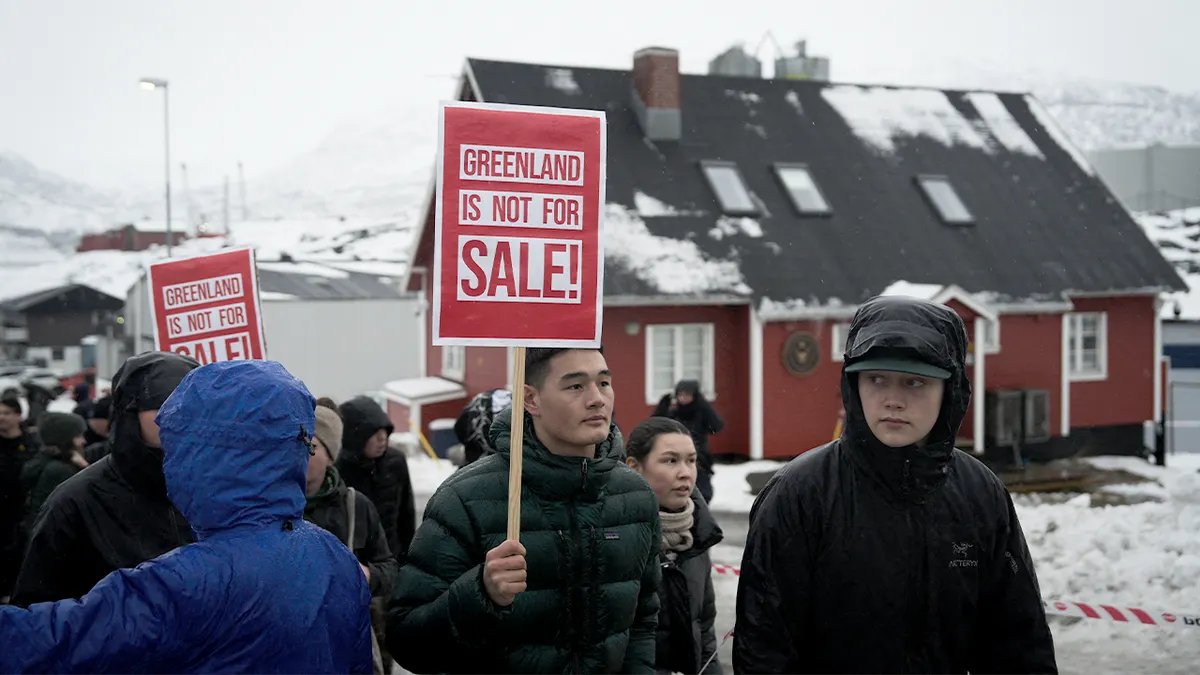 Giovani manifestanti portano cartelli di protesta davanti al consolato americano a Nuuk per opporsi al controllo straniero della Groenlandia.