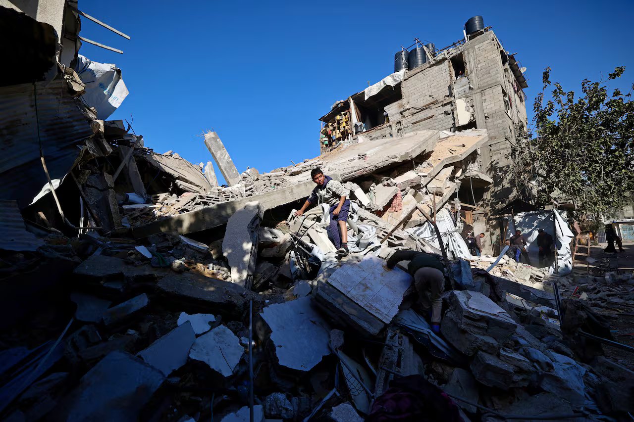 Un bambino si trova tra le rovine di una casa distrutta.