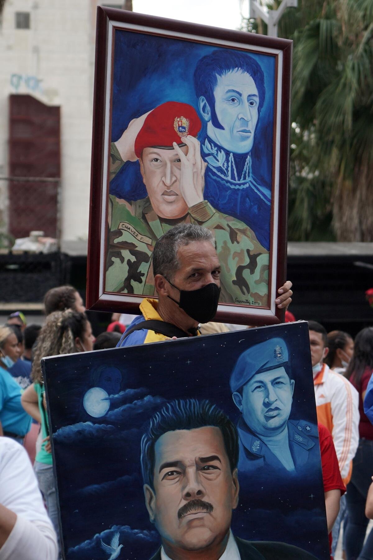 Durante una marcia le persone portano dipinti di Hugo Chavez.