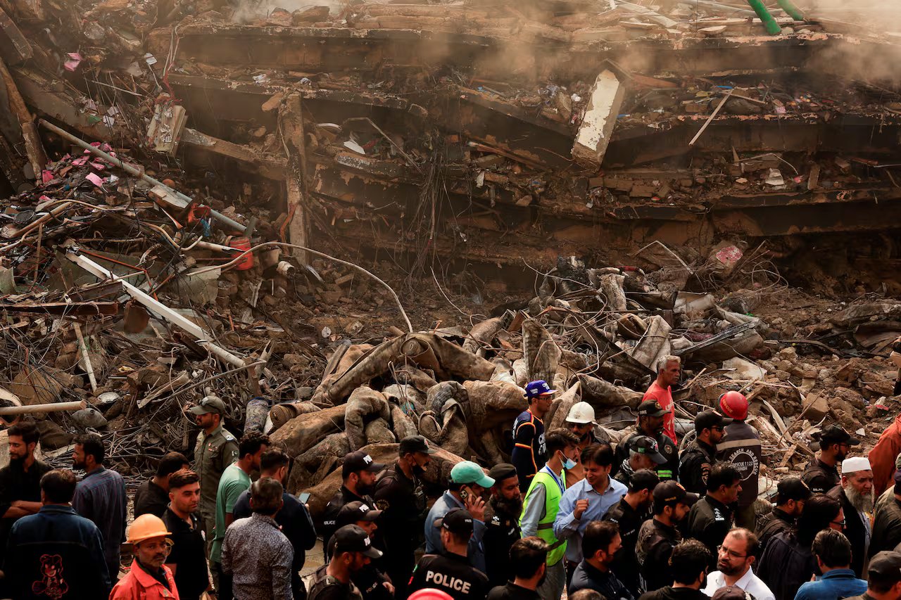 Le persone si radunano davanti all'edificio crollato.