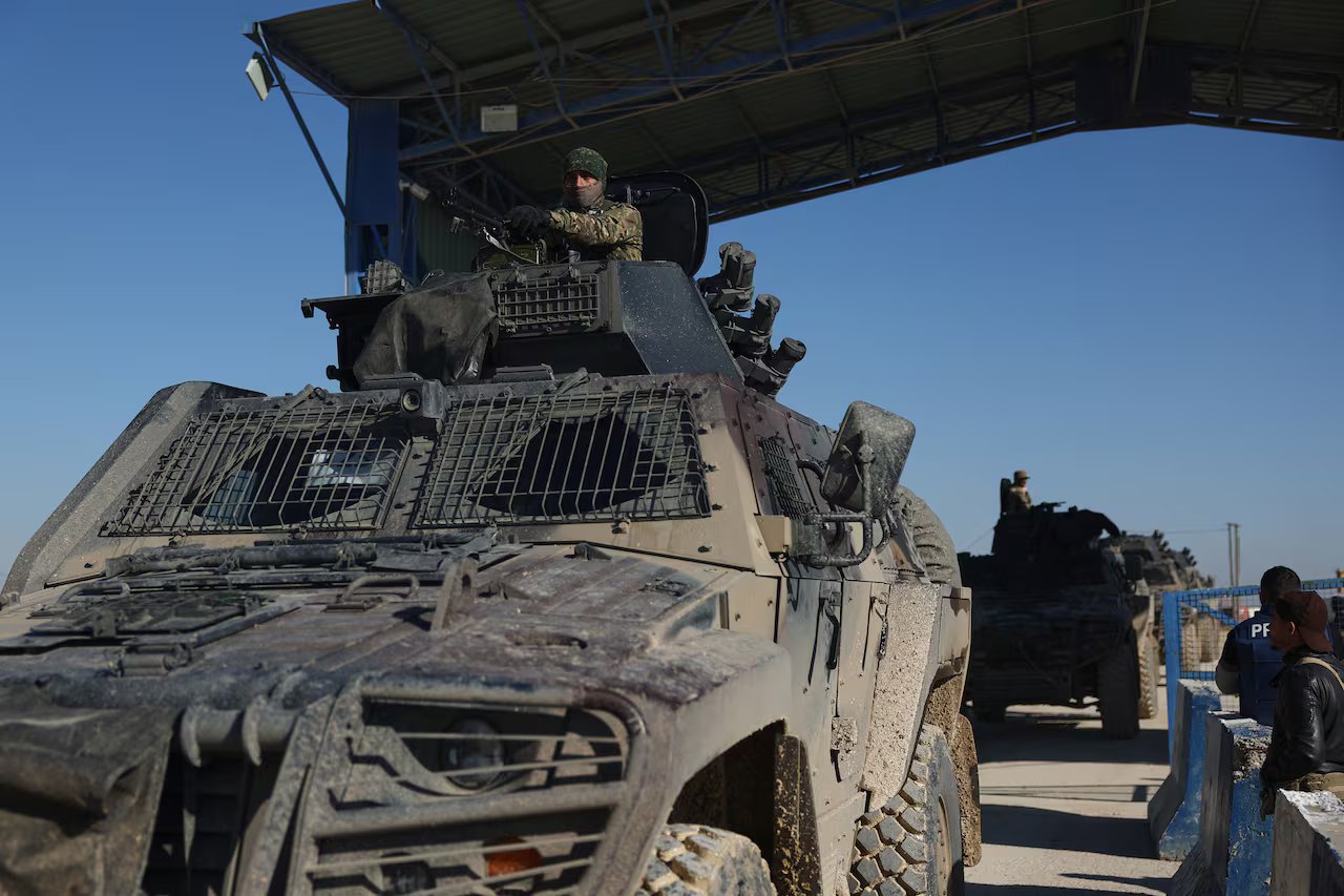 Si vede una fila di veicoli blindati dirigersi verso la telecamera che scatta la foto