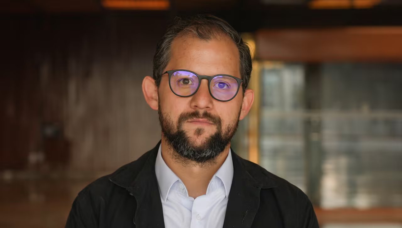 Uomo che indossa gli occhiali guardando la telecamera.