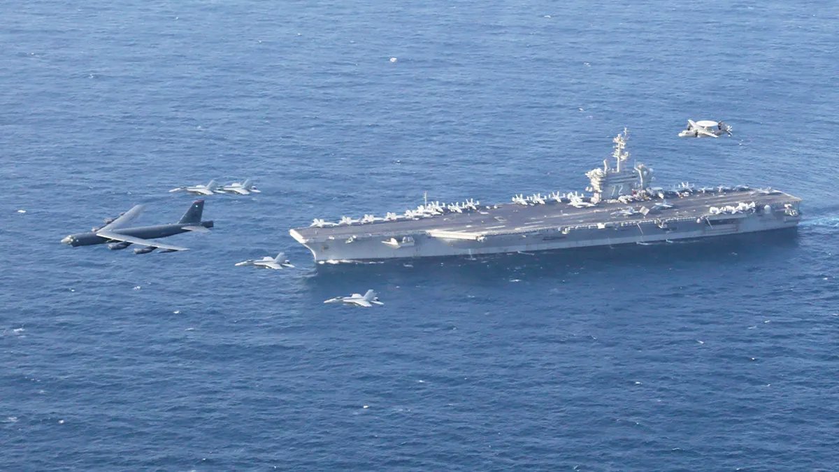 La portaerei USS Abraham Lincoln e un aereo B-52H Stratofortress dell'aeronautica americana