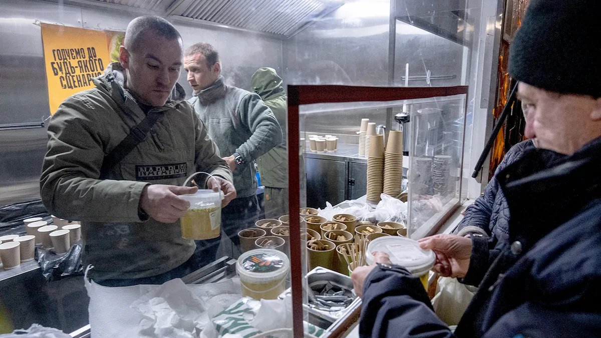 Veterani militari distribuiscono cibo caldo ai residenti in un quartiere colpito da un'interruzione di corrente.
