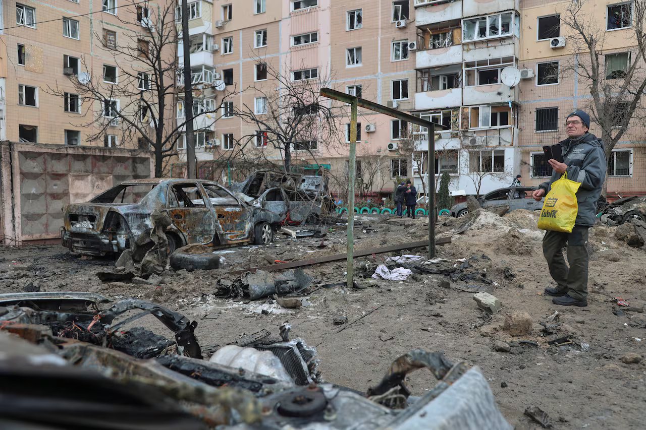 Veicoli danneggiati sono visibili nel cortile di un edificio. 