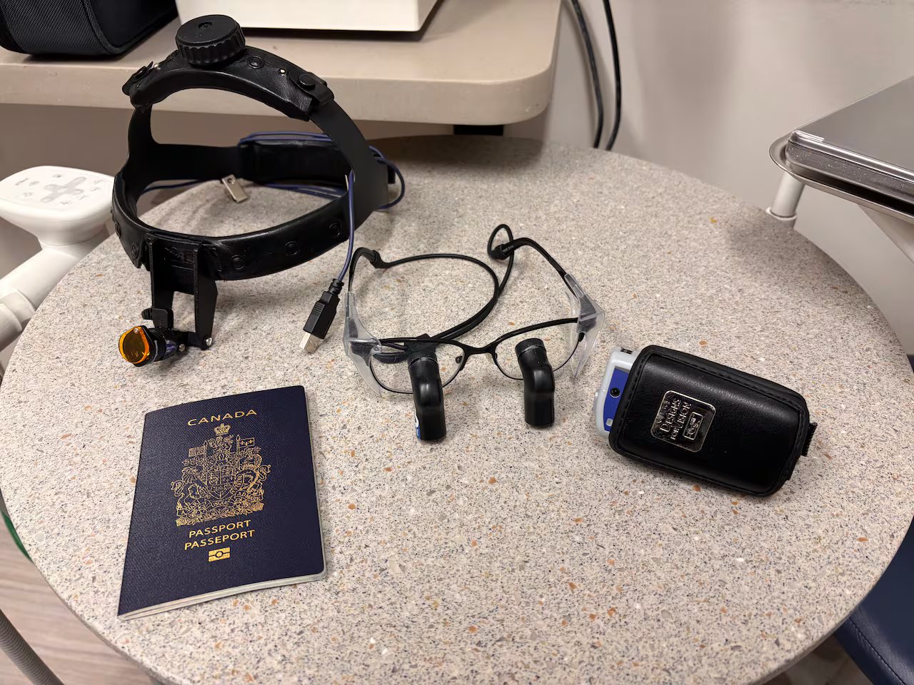 Su un tavolo si trovano un passaporto canadese, una batteria e alcune attrezzature mediche.