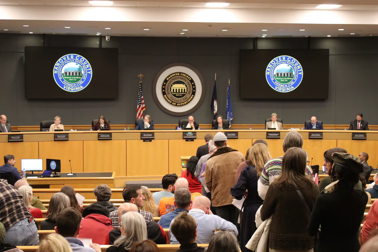 Le persone si mettono in fila per parlare con un gruppo di leader locali in un municipio della Virginia