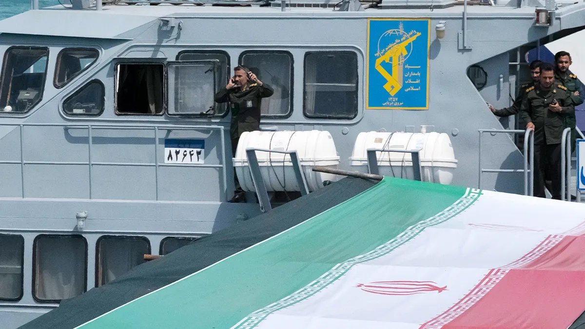 Il personale della Marina in uniforme sta sul ponte di una nave militare durante una parata militare.