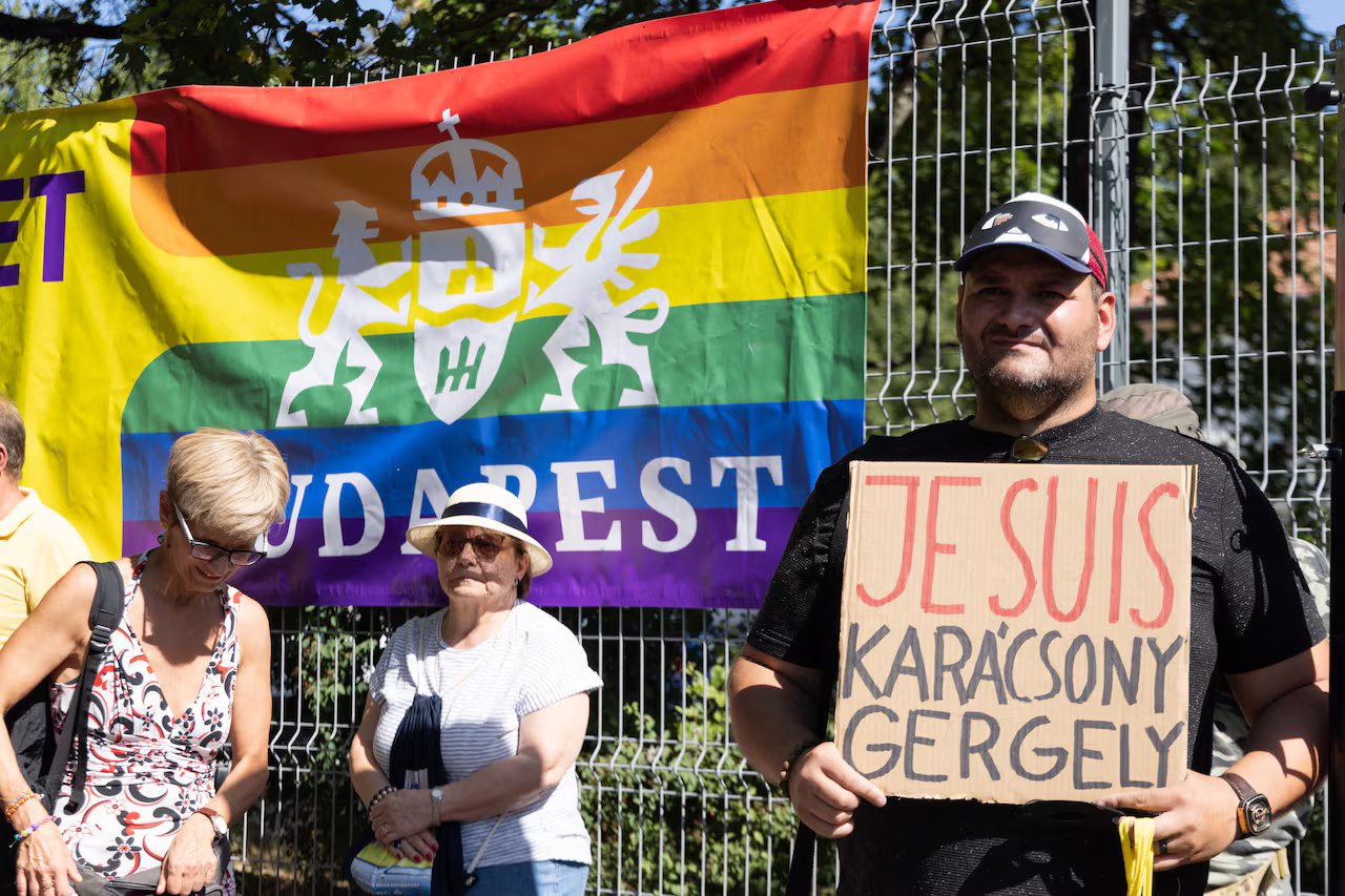 Un uomo tiene in mano un cartello di cartone scritto a mano che recita: 