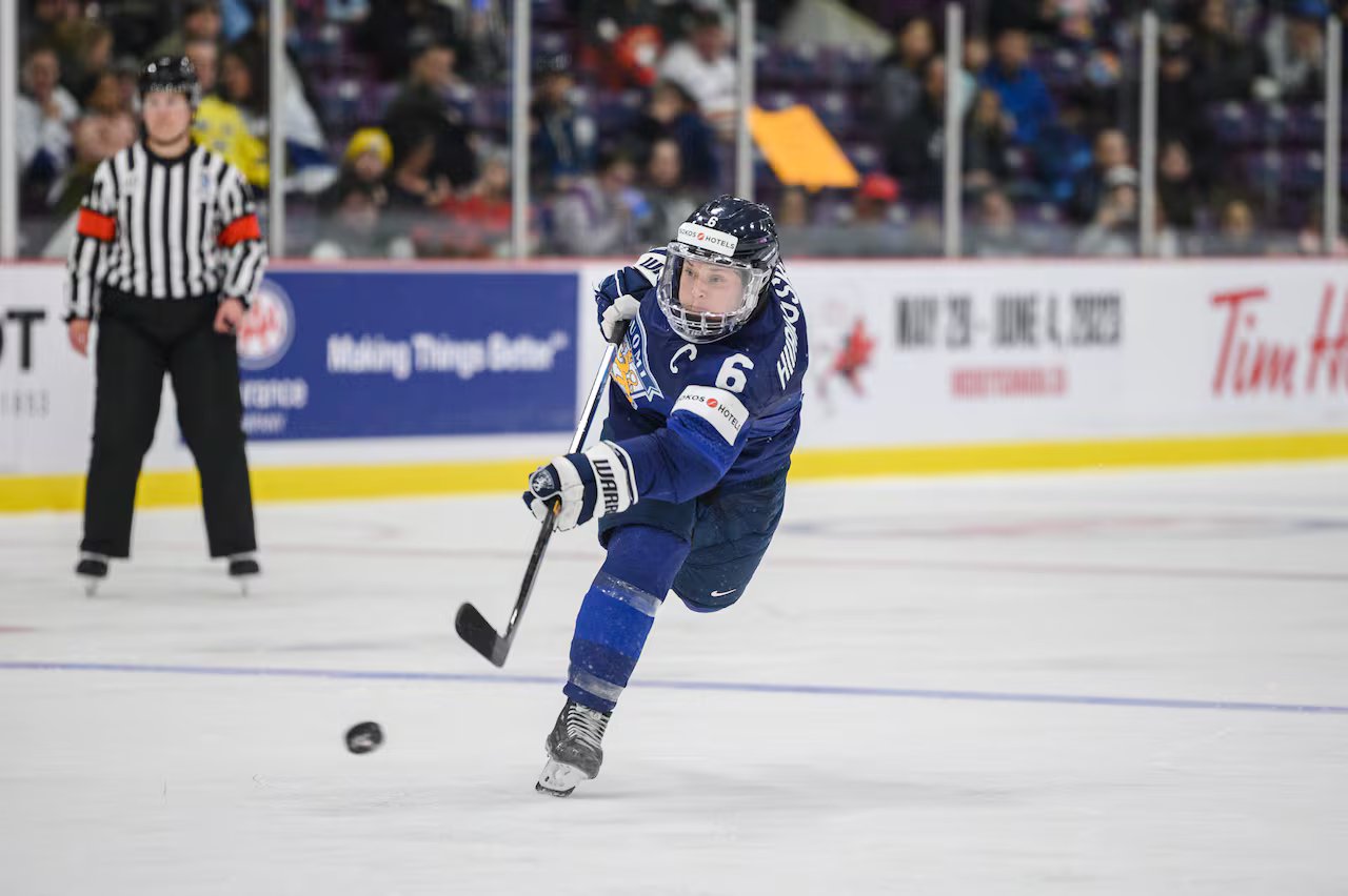 Il giocatore di hockey spara la palla.