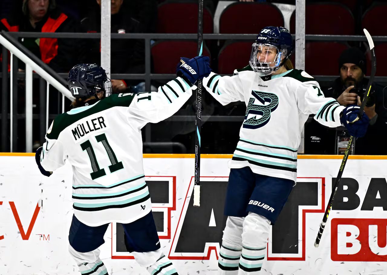 Due giocatori della Boston Fleet festeggiano un gol lungo il tabellone.