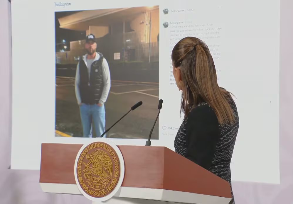 Una donna indica l'immagine di un uomo su un grande schermo