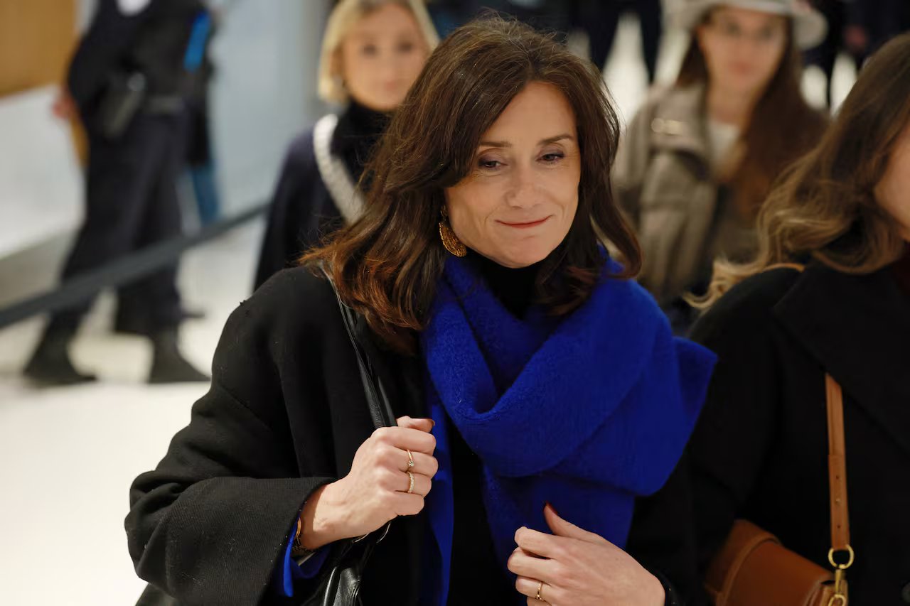 Una donna che indossa una sciarpa blu sorride mentre lo guarda.